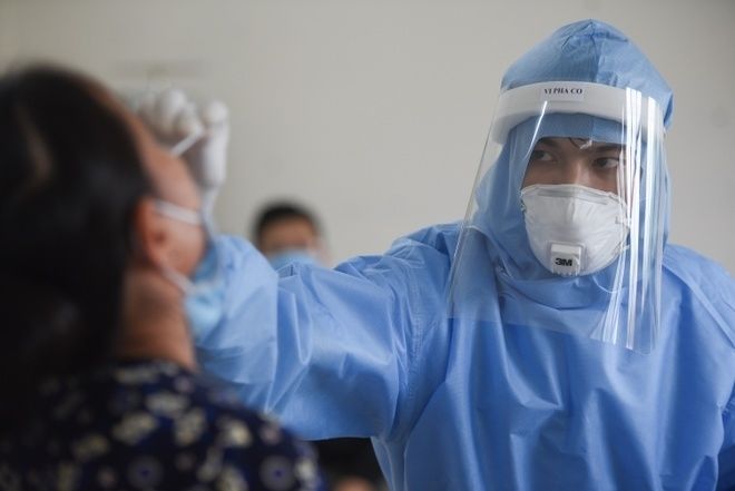 Nhân viên y tế lấy mẫu xét nghiệm Covid-19. (Ảnh: Báo Quốc tế)