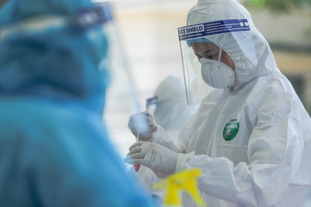 Nhân viên y tế lấy mẫu xét nghiệm Covid-19 (Ảnh: Báo Quốc tế)