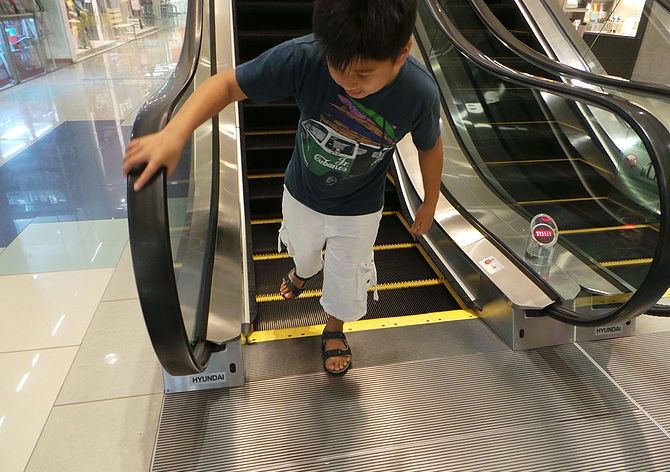 Mẹ lơ là khi đi thang cuốn, bé trai suýt bị nuốt bàn chân phải