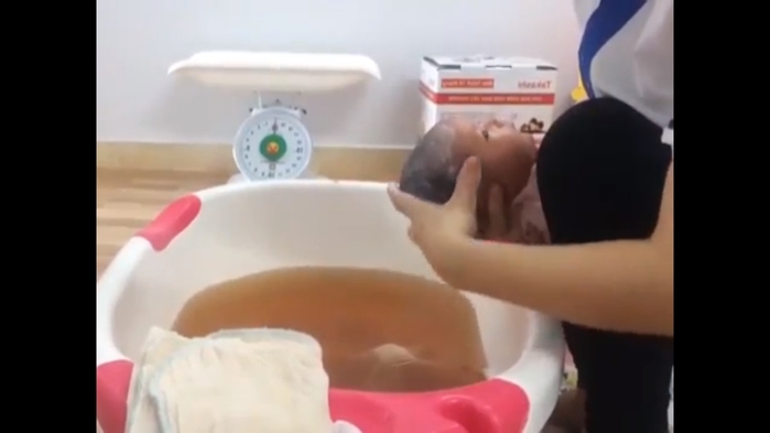 Nữ y tá hướng dẫn tắm cho trẻ sơ sinh đúng chuẩn