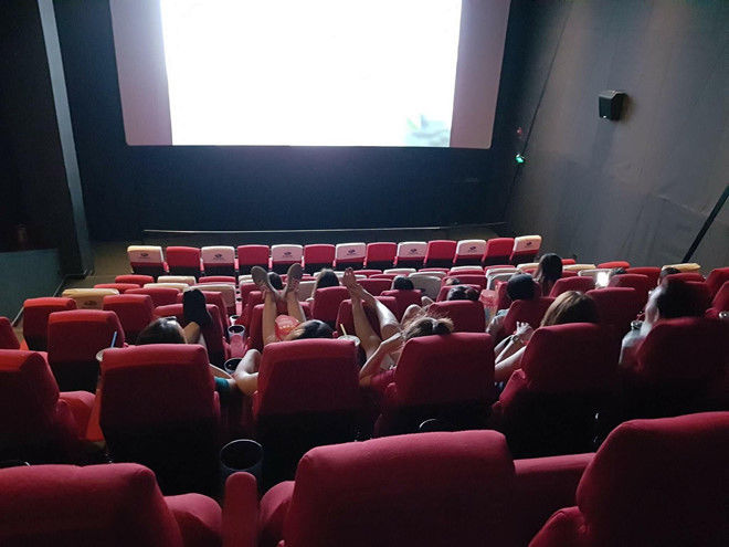 Vô tư gác chân lên đầu người ngồi trước trong rạp phim