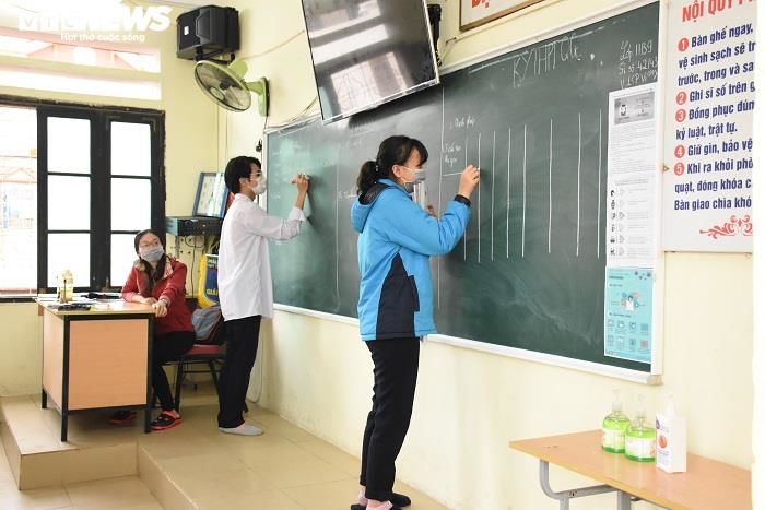 Giáo viên phát khẩu trang, kiểm tra sức khỏe đón học sinh trở lại