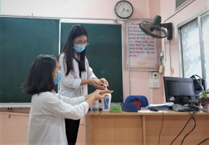 Giáo viên phát khẩu trang, kiểm tra sức khỏe đón học sinh trở lại