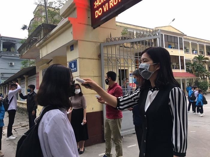Giáo viên phát khẩu trang, kiểm tra sức khỏe đón học sinh trở lại