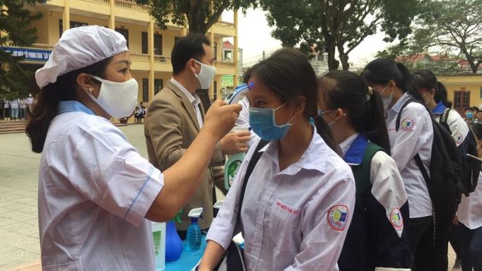 Giáo viên phát khẩu trang, kiểm tra sức khỏe đón học sinh trở lại