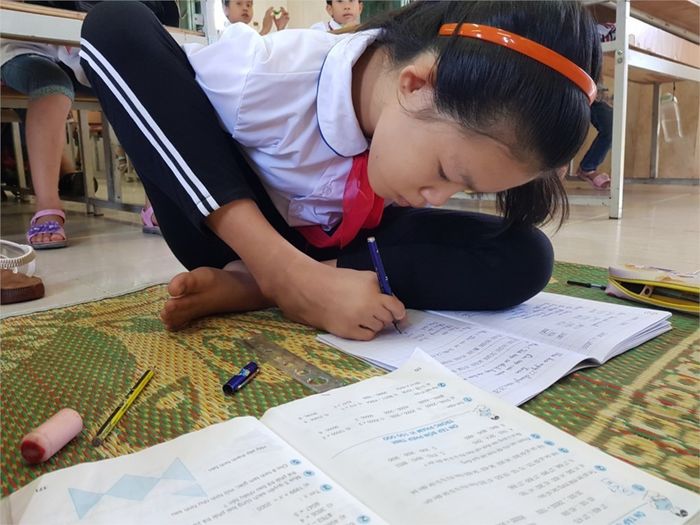 Khiếm khuyết hai cánh tay, cô bé người Sán Dìu dùng chân viết chữ