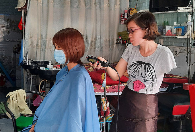 Người phụ nữ 1 tay làm nghề cắt tóc nuôi con