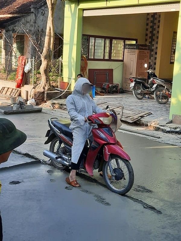 Người đàn ông chạy xe máy lên đường đang đổ bê tông