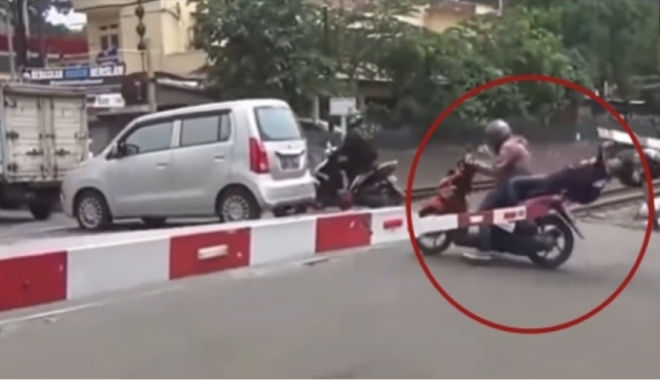 Cô gái suýt gãy cổ vì bạn trai cố lao qua thanh chắn tàu hỏa