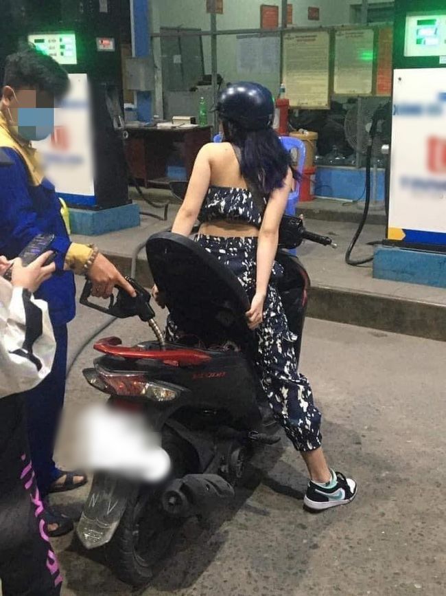 Vào đổ xăng, cô gái ngồi luôn trên yên kệ nhân viên bơm xăng loay hoay