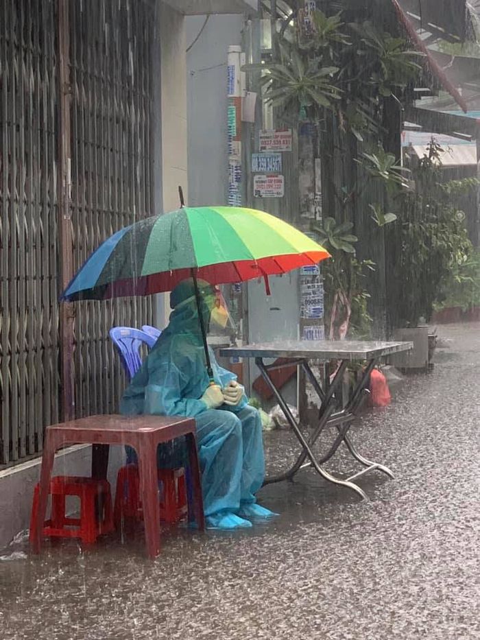 Cảm động hình ảnh TNV đội mưa ngồi ở điểm trực tiêm vắc xin