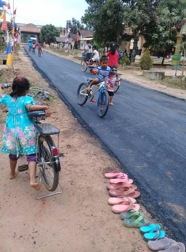Đám trẻ con tự cởi giày đi chân đất vì sợ làm bẩn con đường mới 