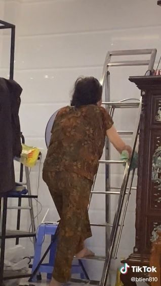 Người vợ trèo thang đứng tâm sự với di ảnh của chồng gây xúc động