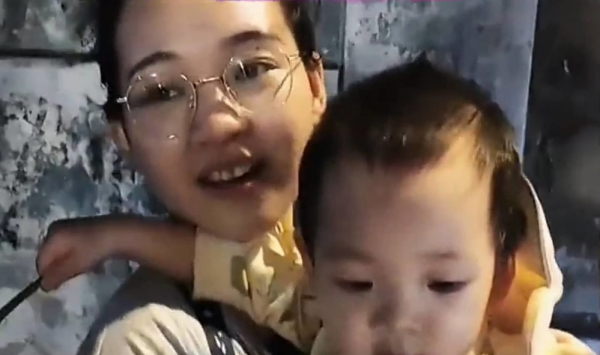 Em bé đội áo mưa đi theo mẹ bán hoa mưu sinh: Ai cũng nghẹn lòng