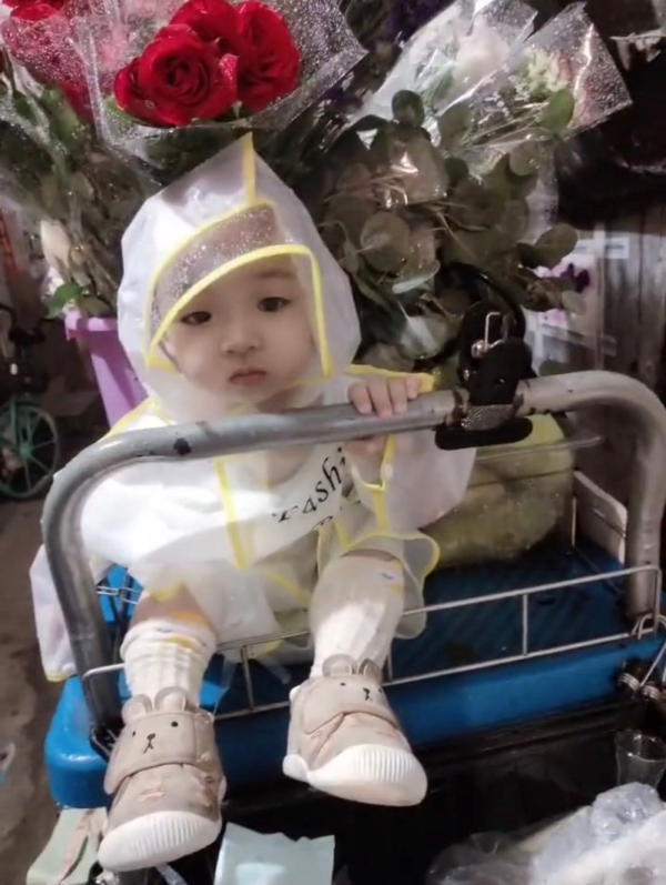 Em bé đội áo mưa đi theo mẹ bán hoa mưu sinh: Ai cũng nghẹn lòng