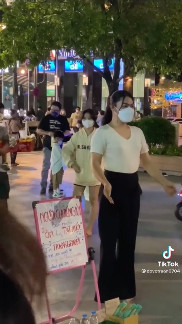 Cô nàng gây chú ý với tấm bảng ôm hay tạt nước người chuyển giới