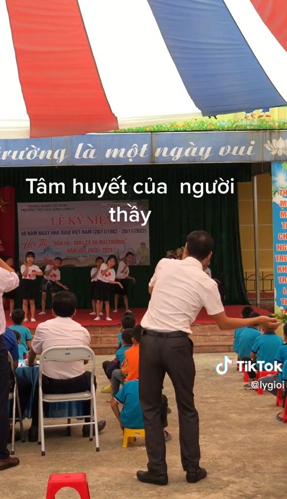 Người thầy hăng say đứng dưới sân khấu nhắc bài cho học sinh