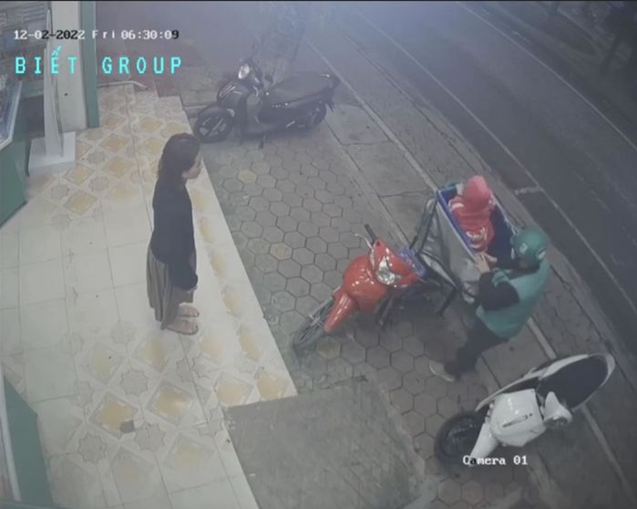 Người cha shipper bế con nằm trong thùng hàng để tránh gió