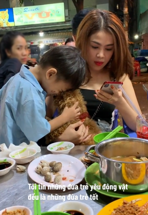 Cay mắt hình ảnh cậu bé bán hàng rong âu yếm chú cún của khách
