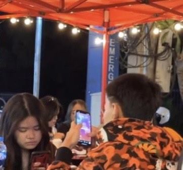 Ngồi trên bàn ăn, chàng trai cầm điện thoại lén chụp ảnh người yêu